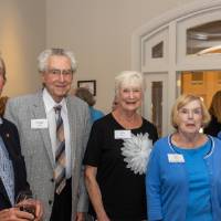 Group of five standing together and smiling for photo